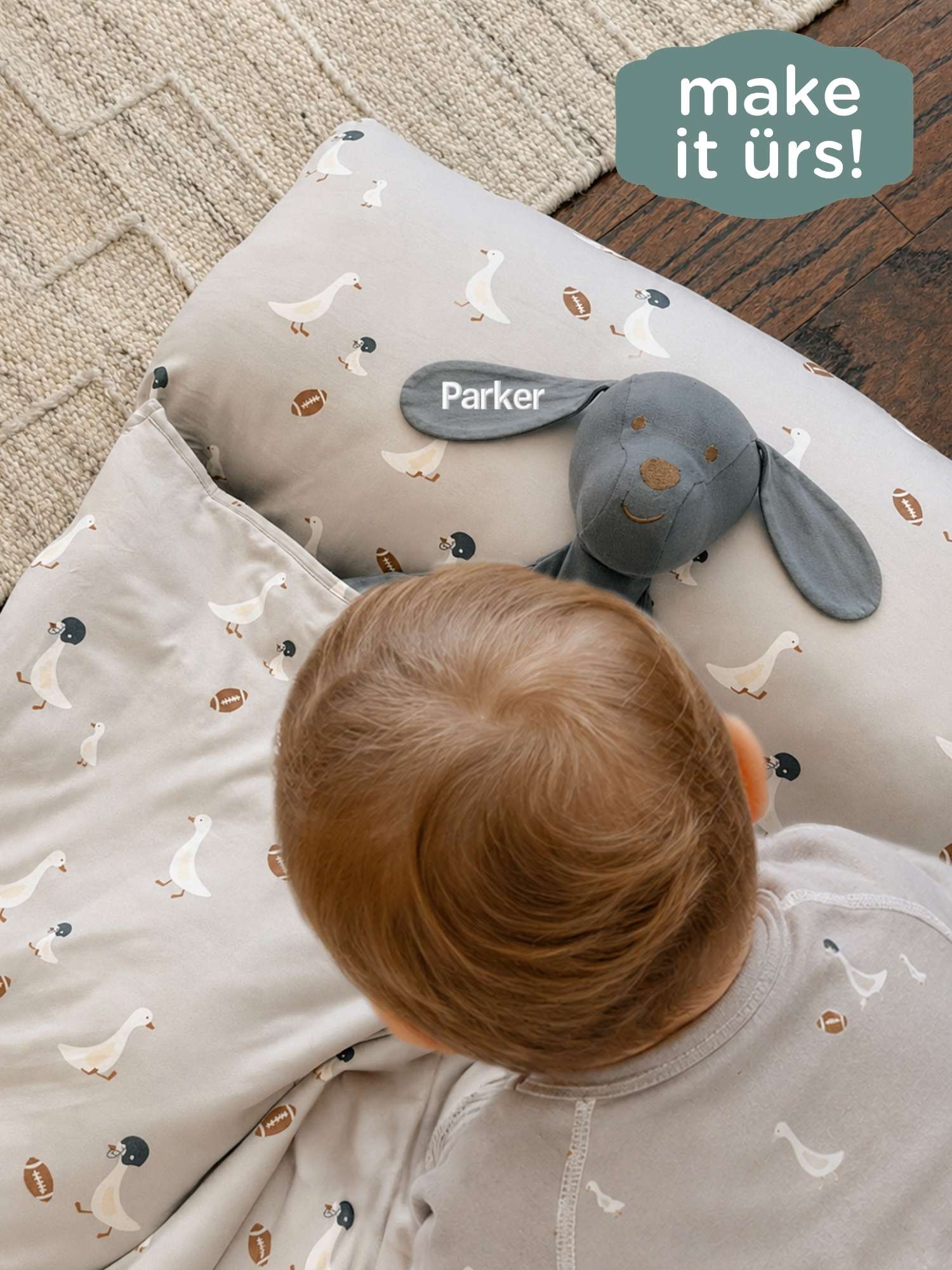 Neutral blanket with allover duck print, plush pup toy, and tag reading Parker