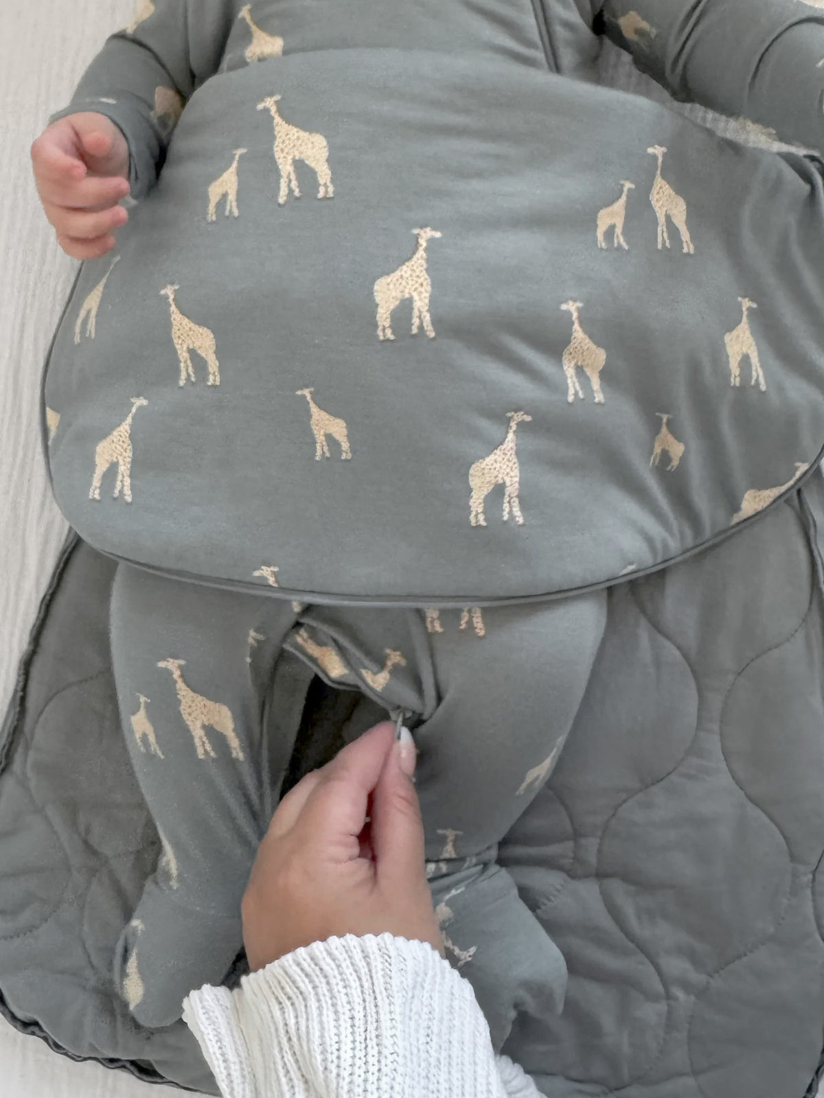 Baby swaddle sleep sack with beige giraffe print and visible arm openings