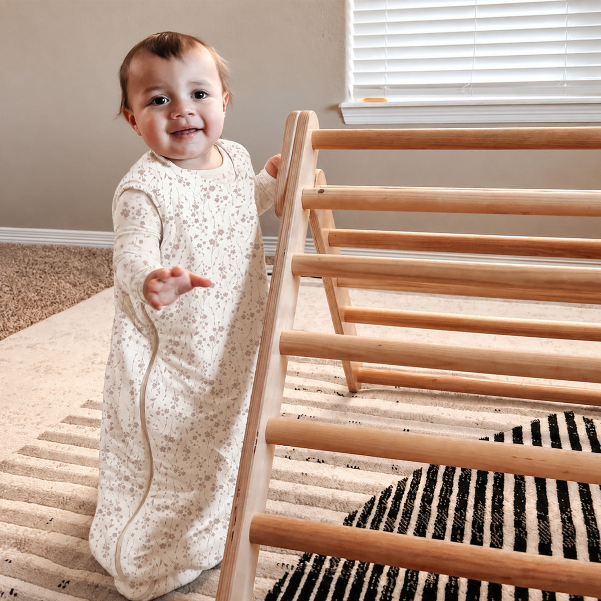Toddler wearing beige floral sleep sack with zipper front and long sleeves
