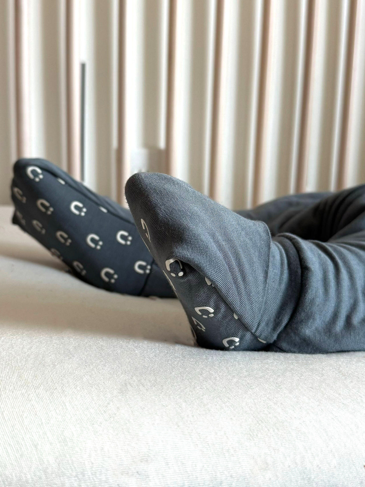 Hush 2.5 TOG footie sleep sack with blue-gray legs and dark patterned covered feet