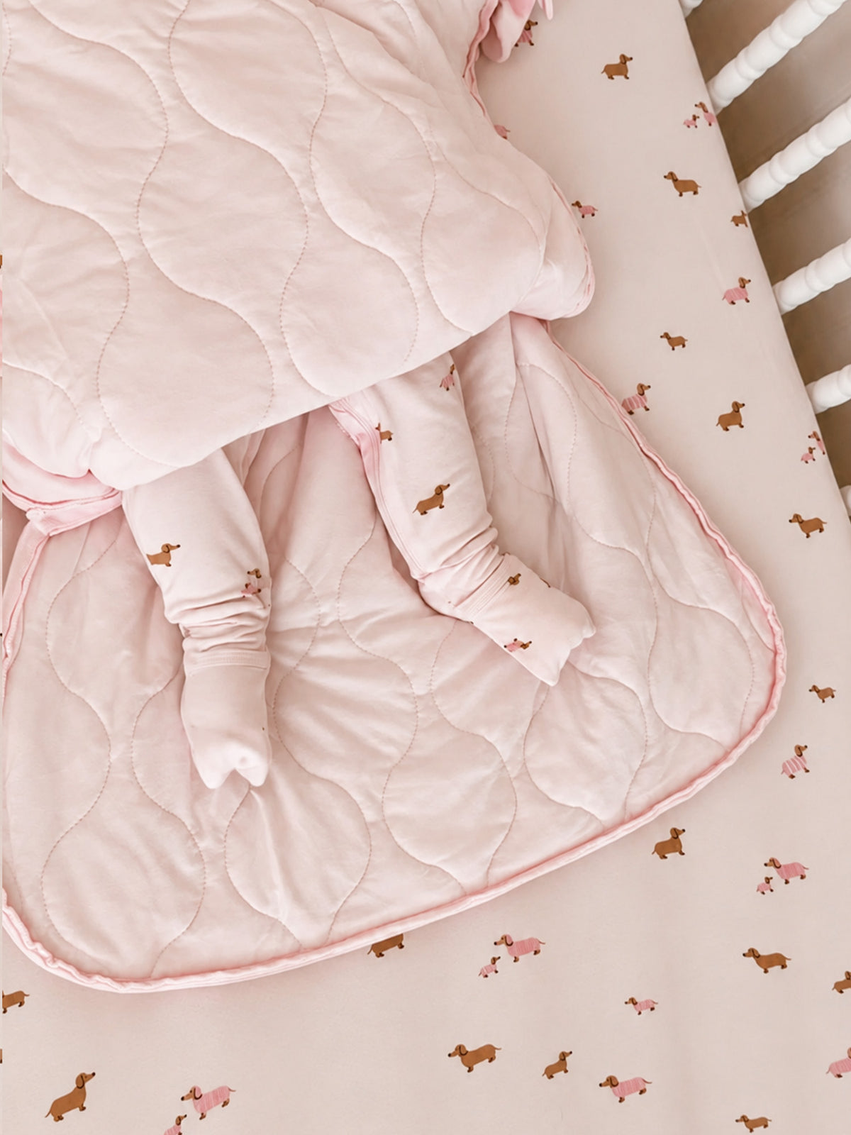 Quilted pink lining sleep sack with dog-print outer, seam details at bottom