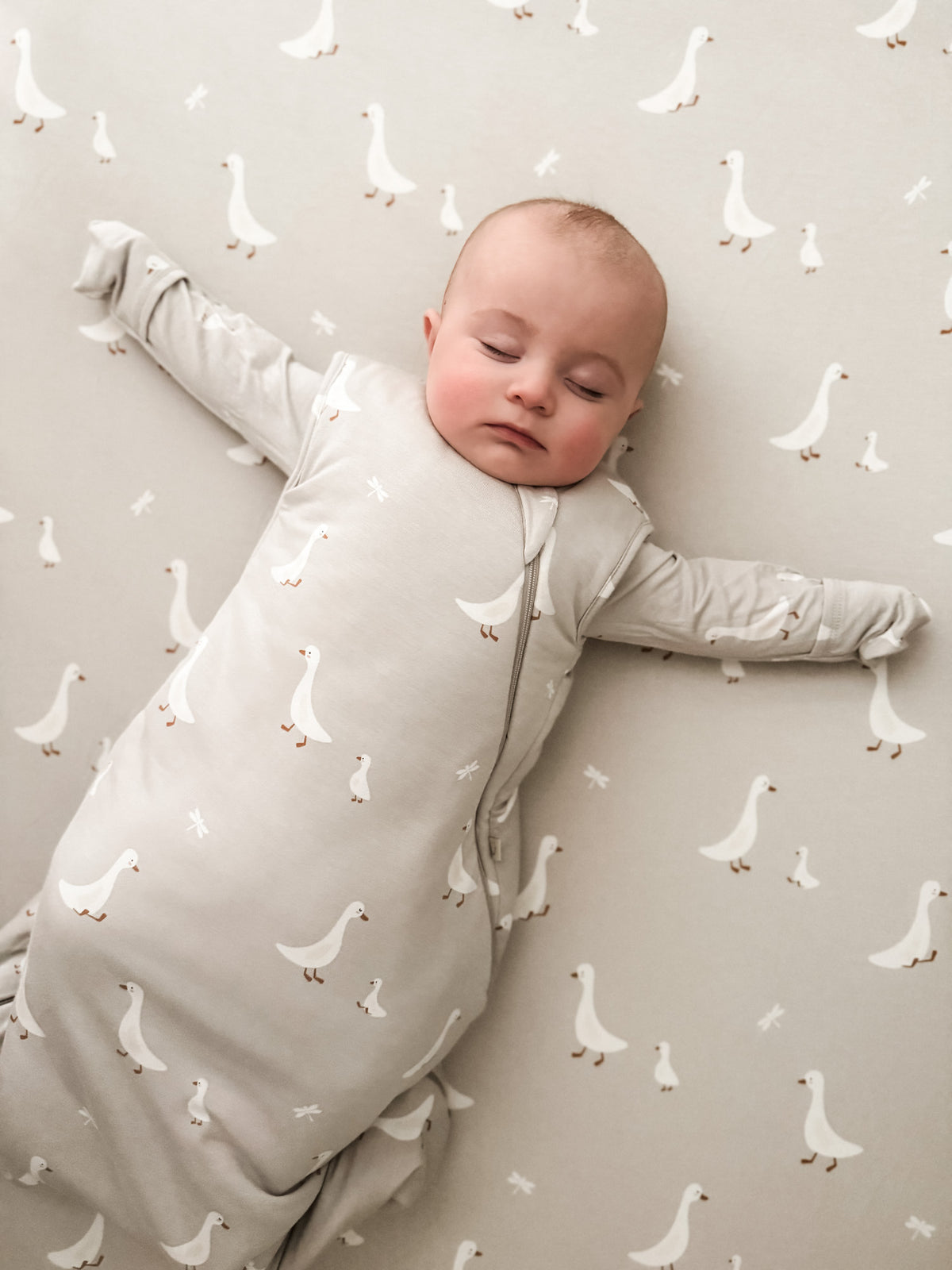Goose-print crib sheet in light neutral fabric with small white goose motifs