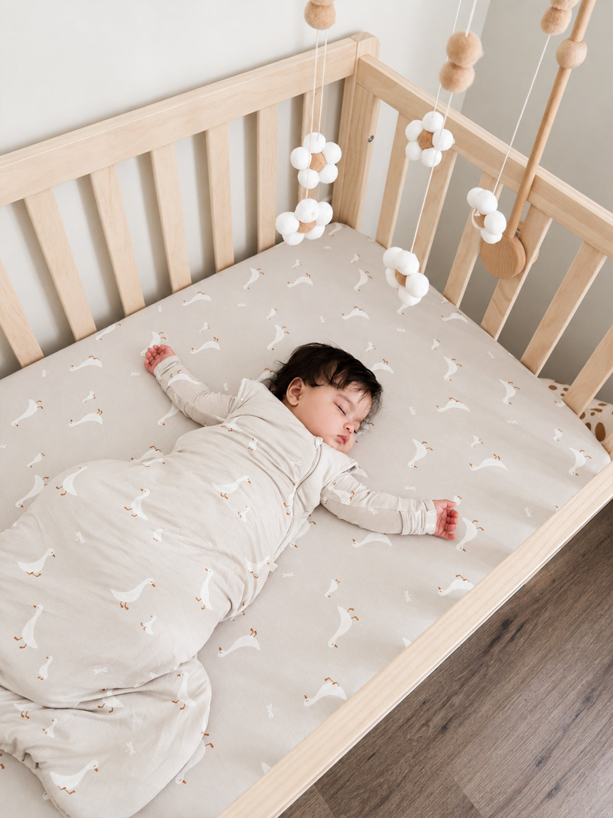 Fitted crib sheet in beige with a small white goose and star pattern