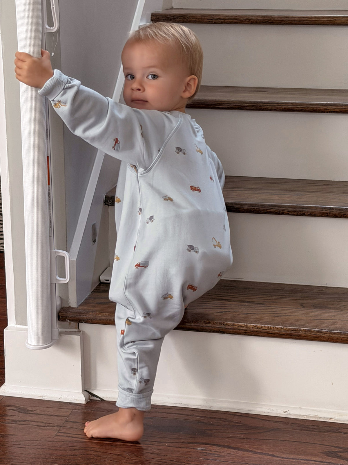 Fleece baby jumpsuit in light gray with colorful vehicle print, full-body coverage