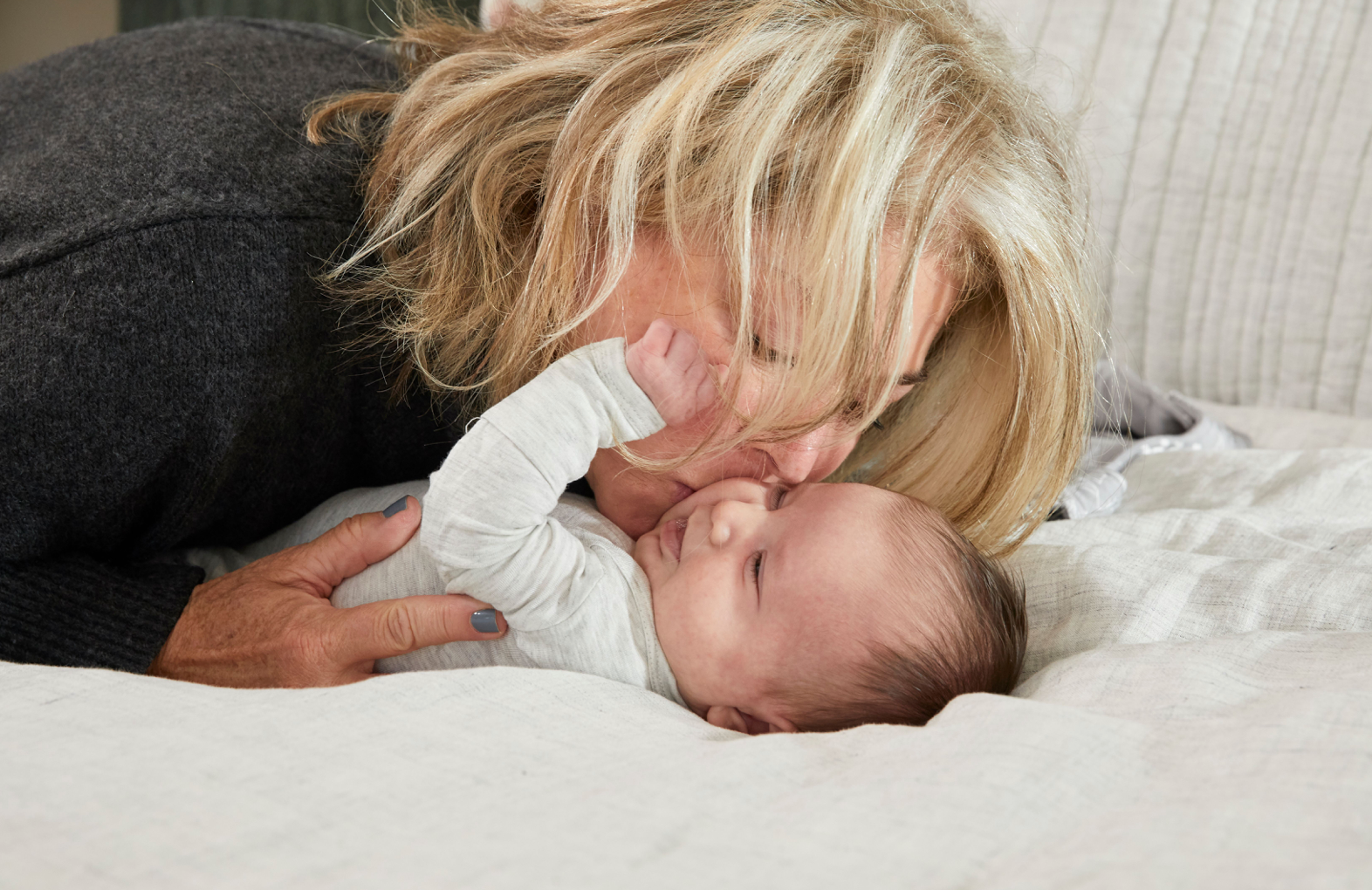 mother kissing her newborn baby