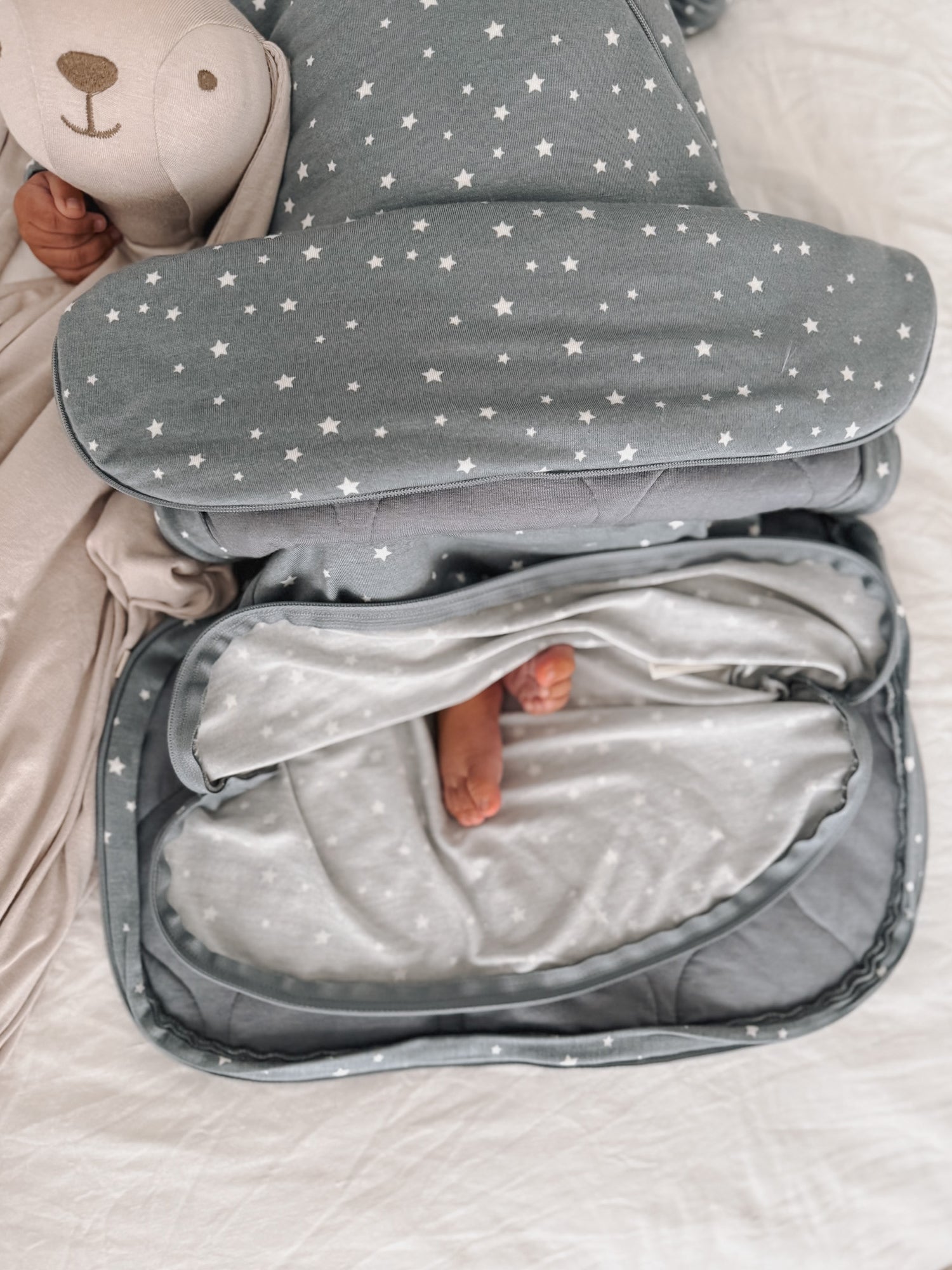 Folded gray sleep sack with white stars, open center showing soft inner lining.