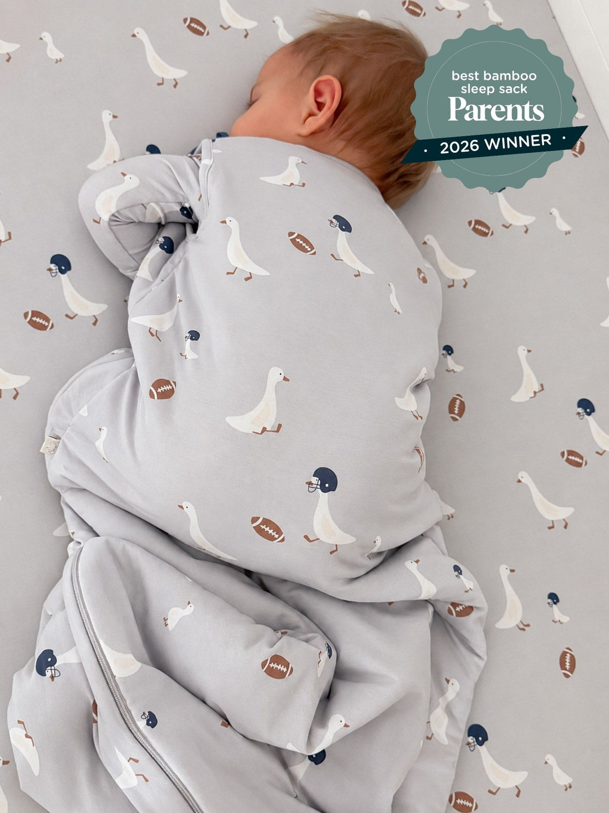 Light gray baby sleep sack with duck and football print, zip front and padded sleeves