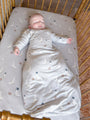 Light gray long-sleeve swaddle sack with bird-and-football print, sleeves for baby's arms