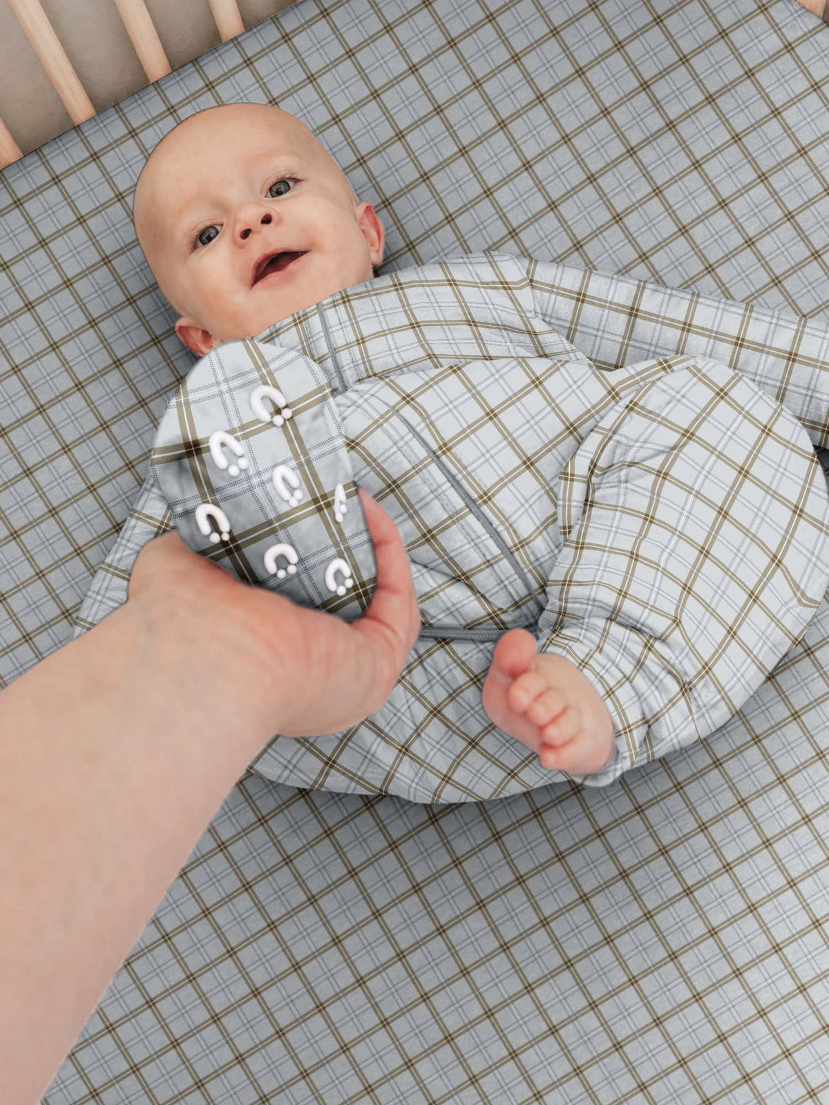 Long sleeve plaid footie sleep sack with front zipper, baby lying on back