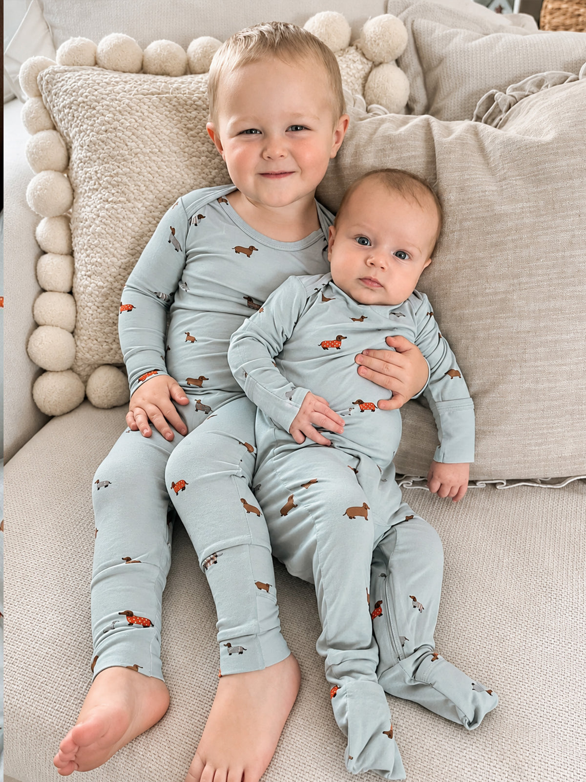 Baby in light blue convertible pajamas with dachshund print, long sleeves and pants