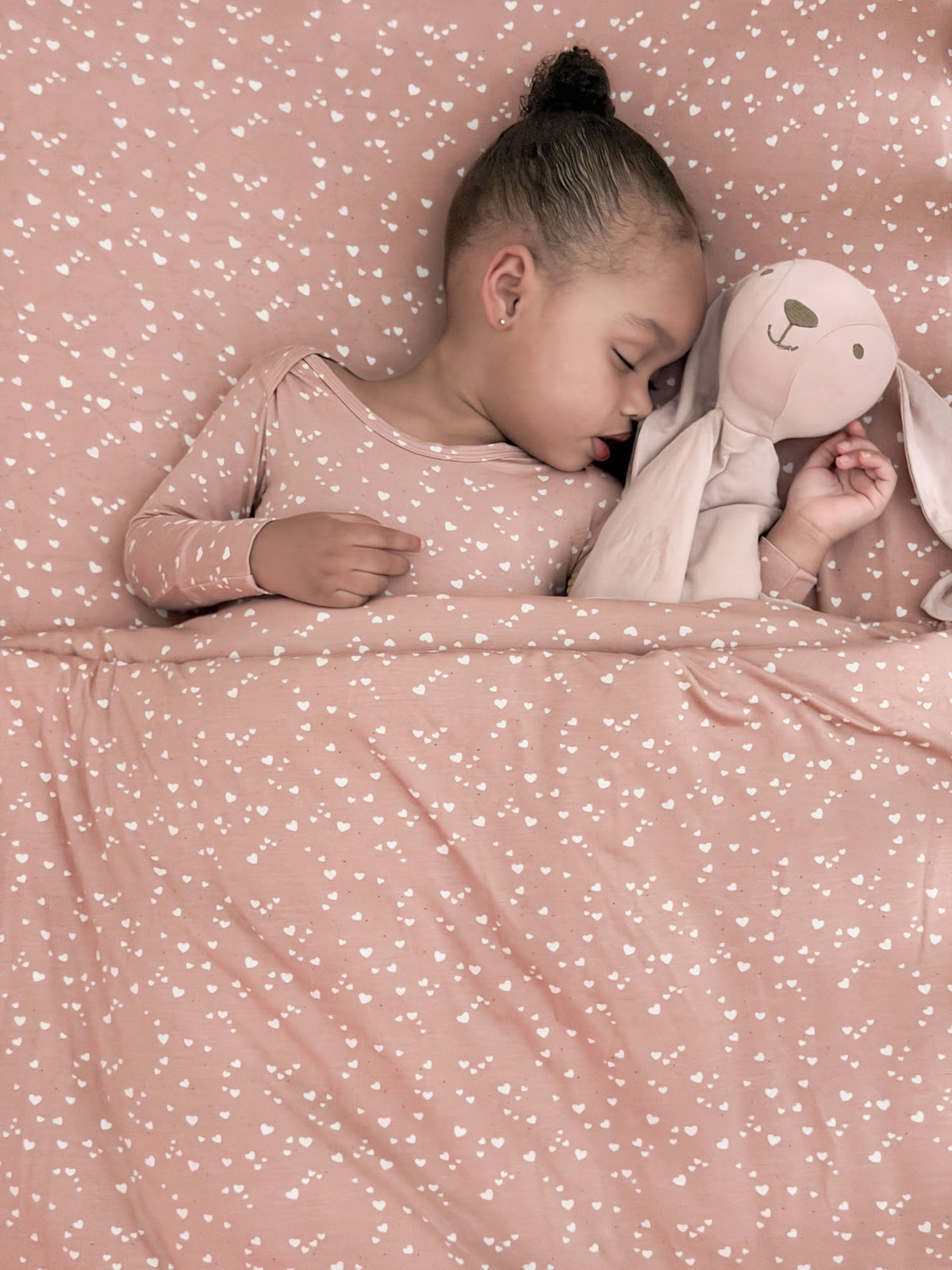Dusty pink heart-pattern cloud blanket draped flat, soft plush fabric