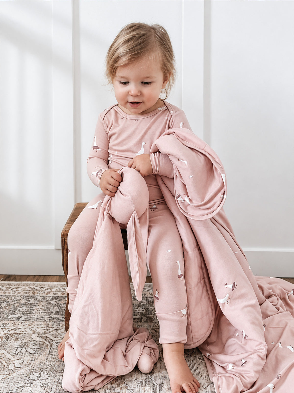 Dusty pink goose-print cloud blanket with long drape, on child