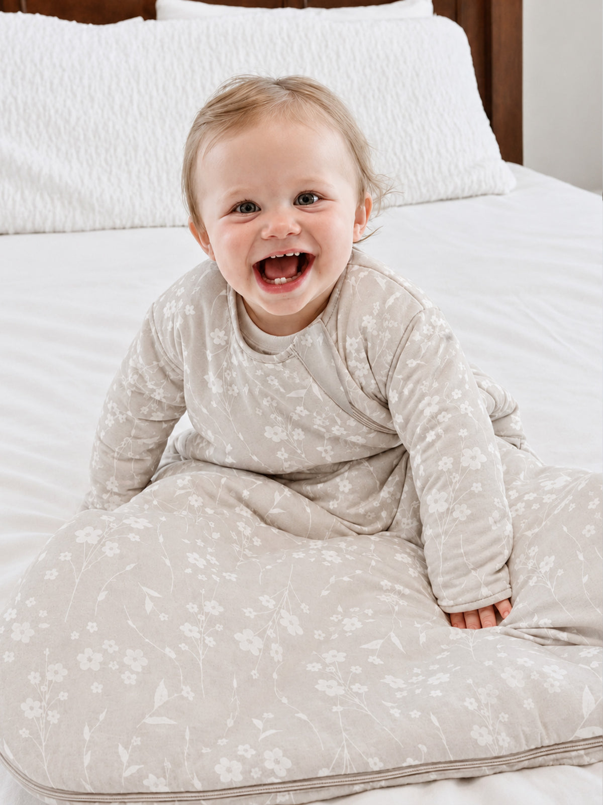 Baby sleep sack with light beige floral print, long sleeves and gathered hem
