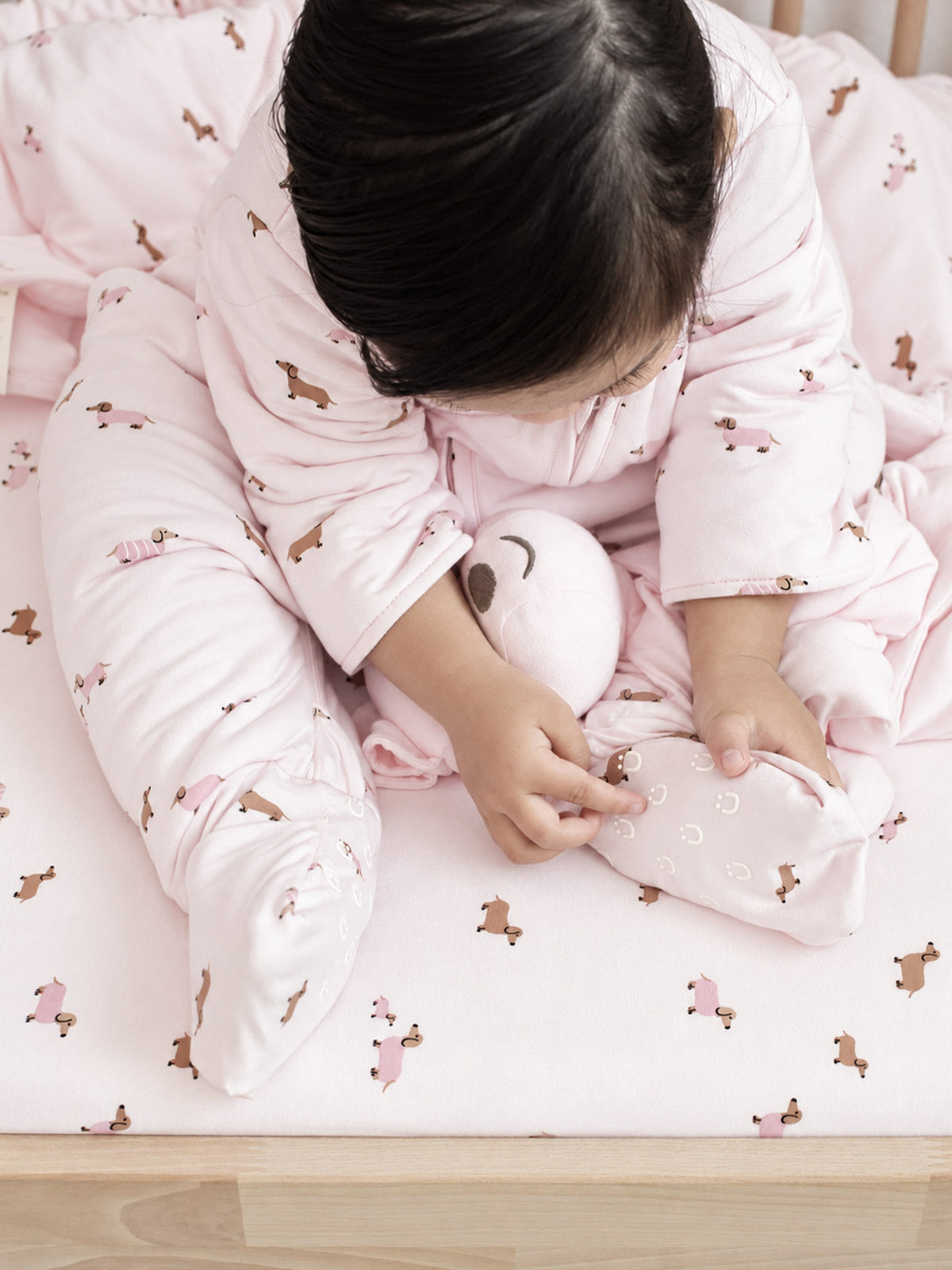 Pink dog-print long-sleeve footie sleep sack with front zip, spread-leg view