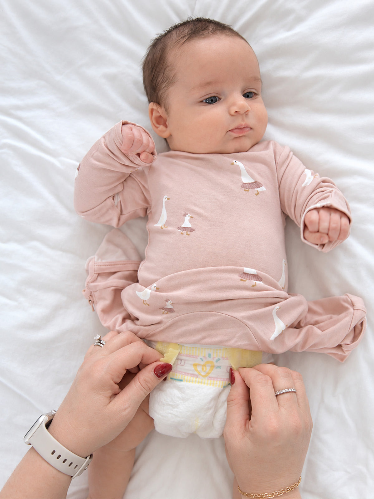 Pink long-sleeve pajama with duck print and mitten-like cuffs, footed legs