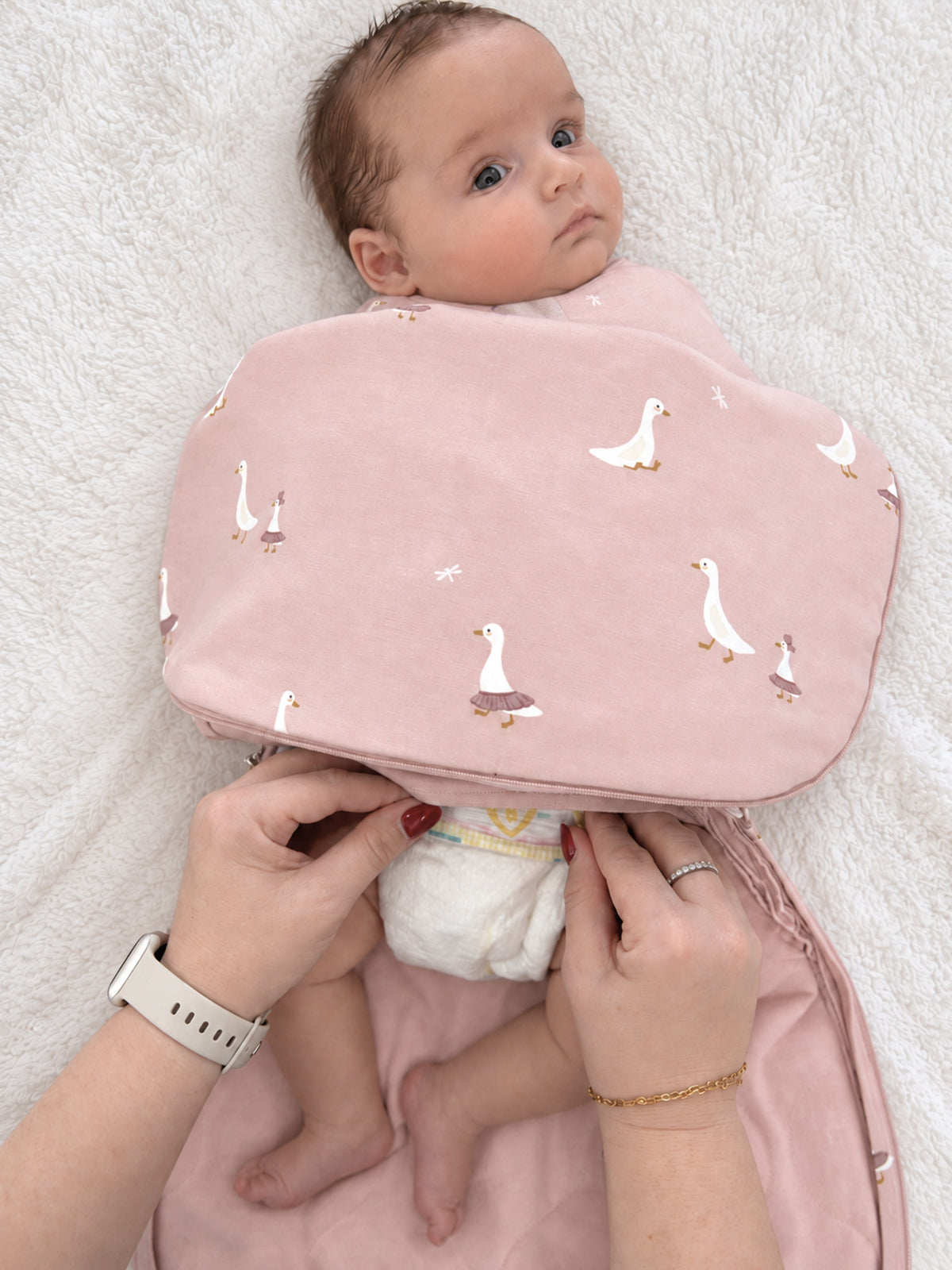 Pink swaddle sleep sack with goose pattern, zippered front and rounded wing shape