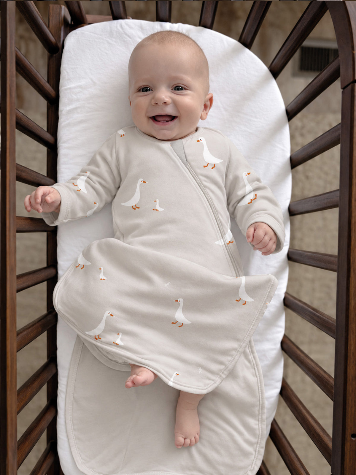 Cream long-sleeve swaddle sleep sack with scattered goose print, zip-front design