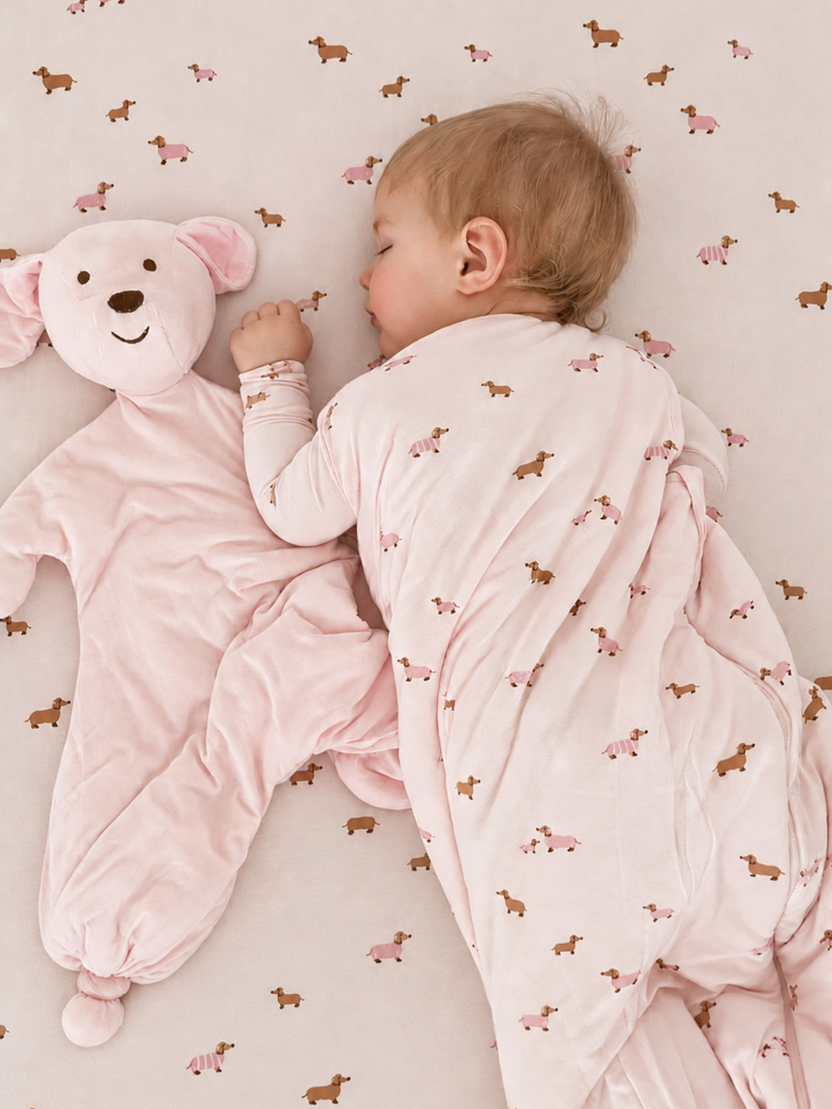 Pink dog-print baby sleep sack with long sleeves and hoodless neckline, side view
