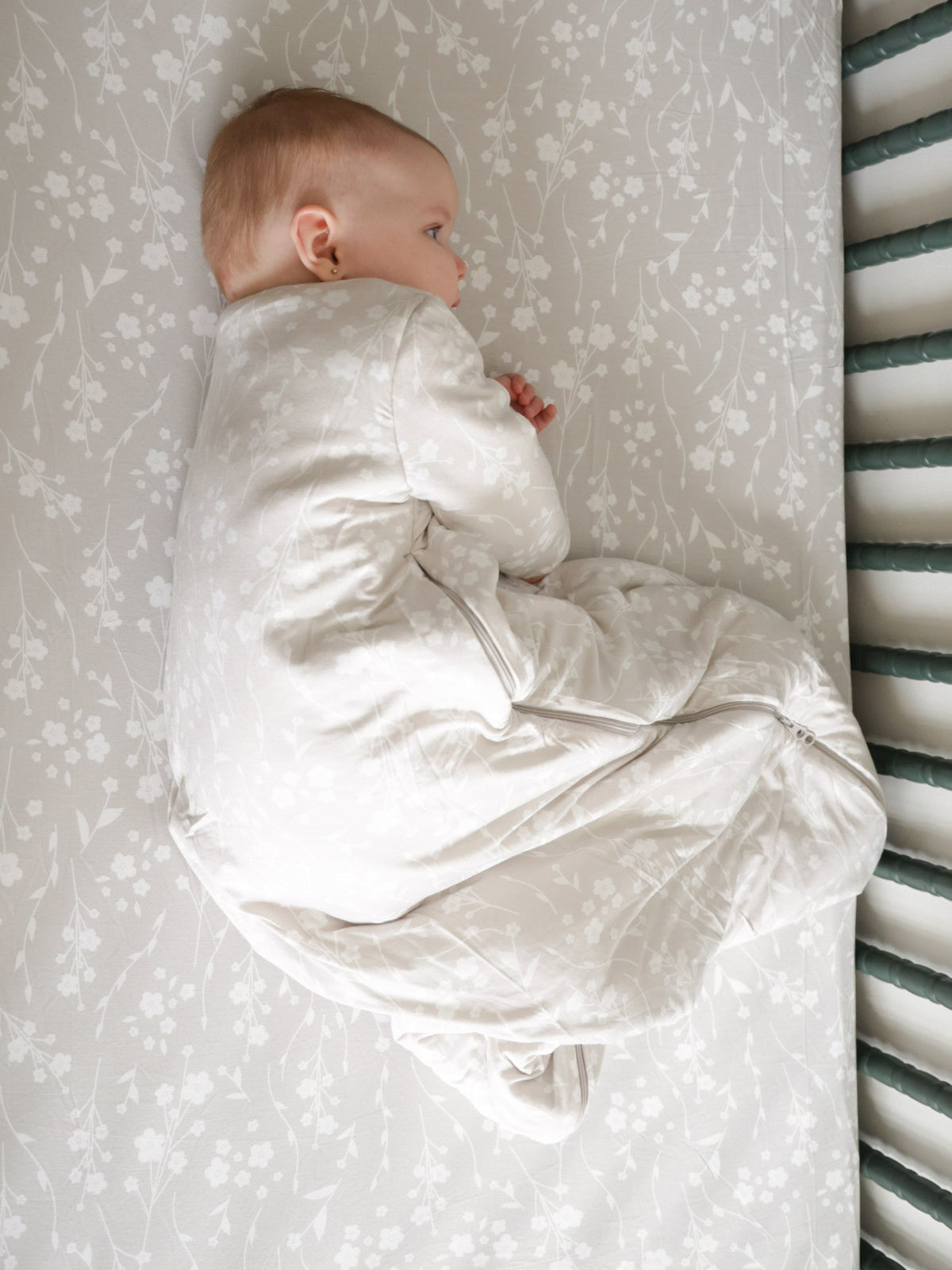 Baby sleep sack with light beige floral print, long-sleeve bodysuit style