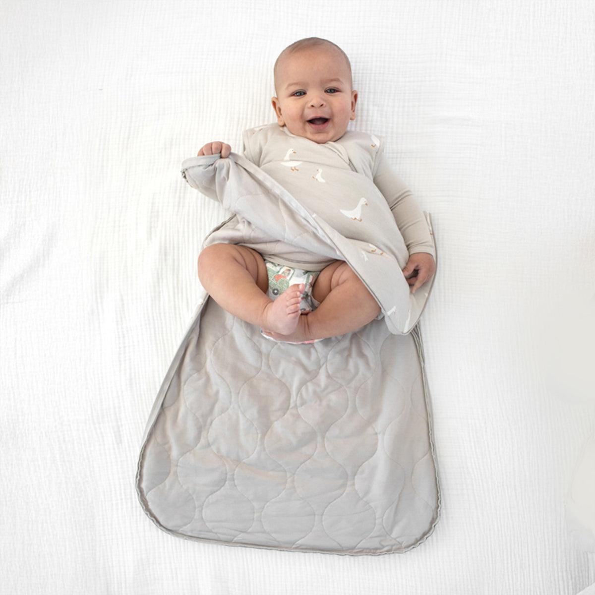 1.0 TOG goose print sleep sack, light gray; baby centered holding arms inside