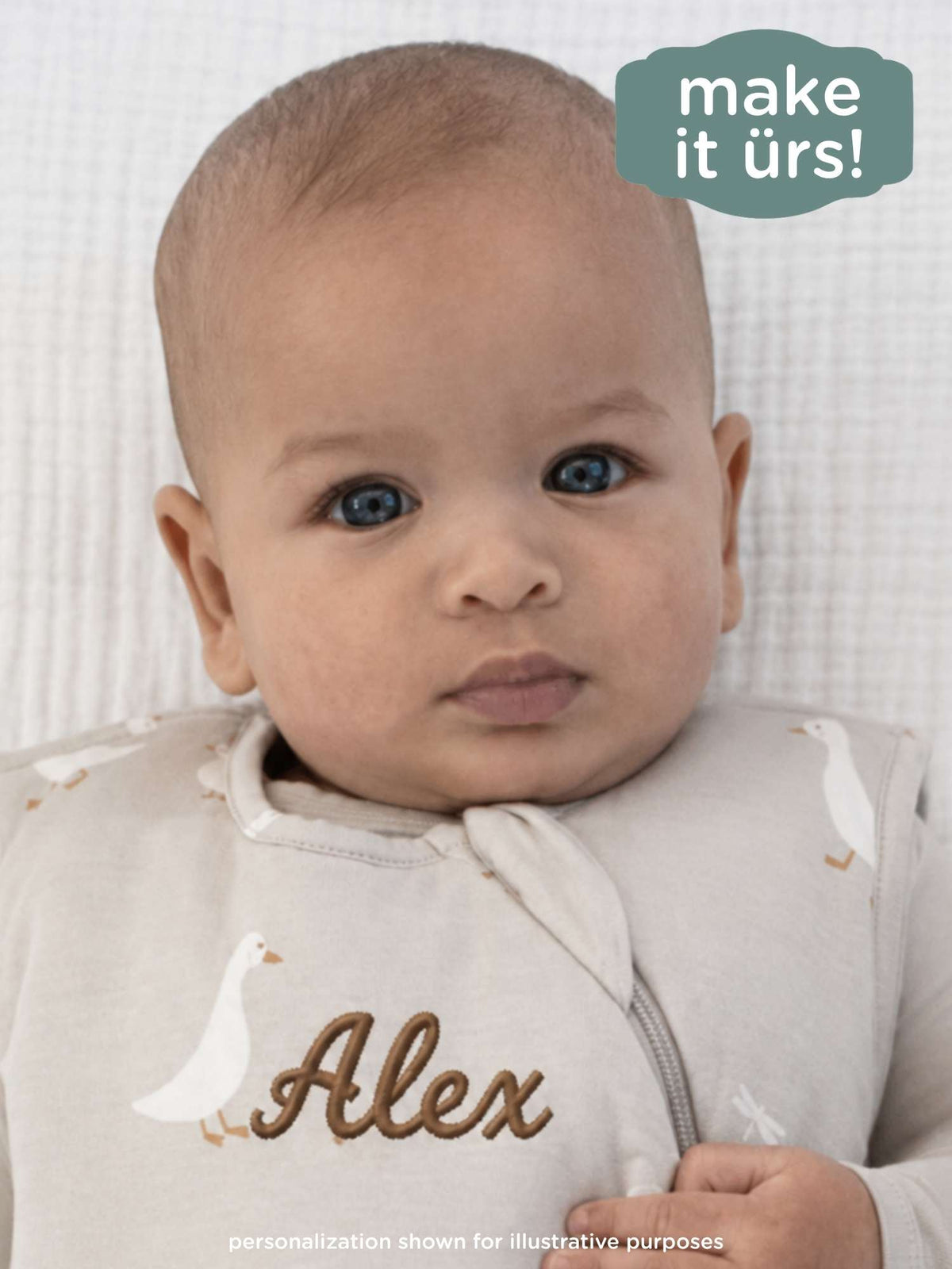 Cream goose-print sleep sack with zip front and personalized name patch “Alex”.
