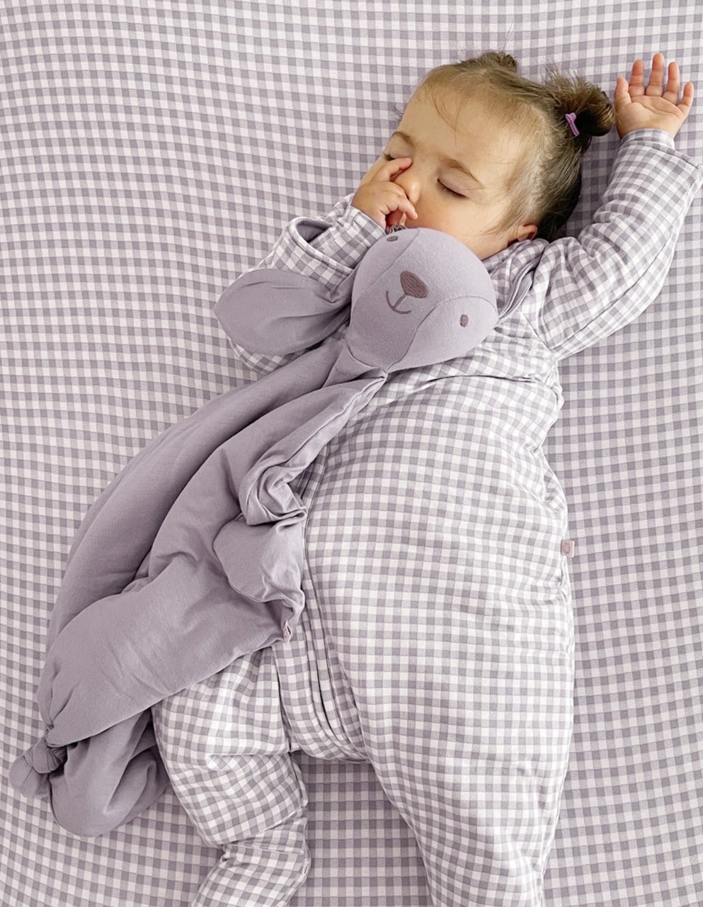 Lavender bunny lovey plush with long ears, held by a sleeping baby
