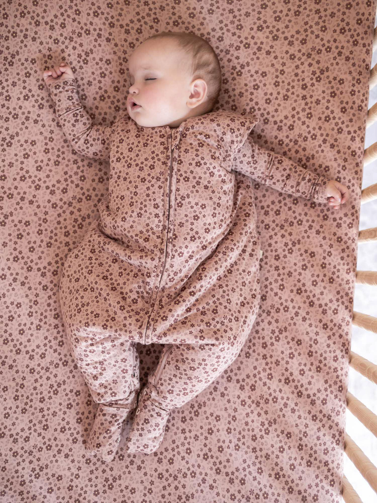 Floral footie sleep sack with front zipper, long sleeves, worn by baby