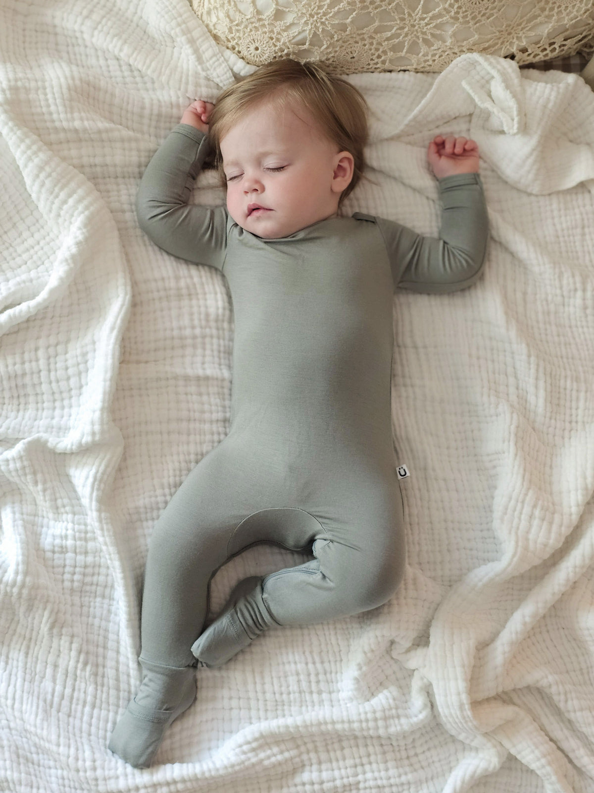 Sage green convertible pajama romper with long sleeves and snap button closure