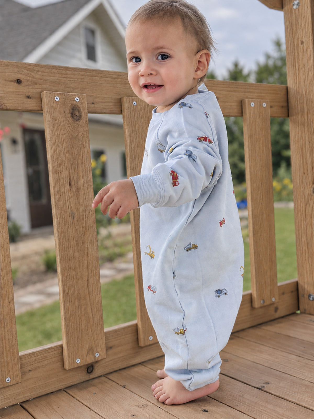 Fleece baby jumpsuit in light gray with allover colorful vehicle print, long sleeves