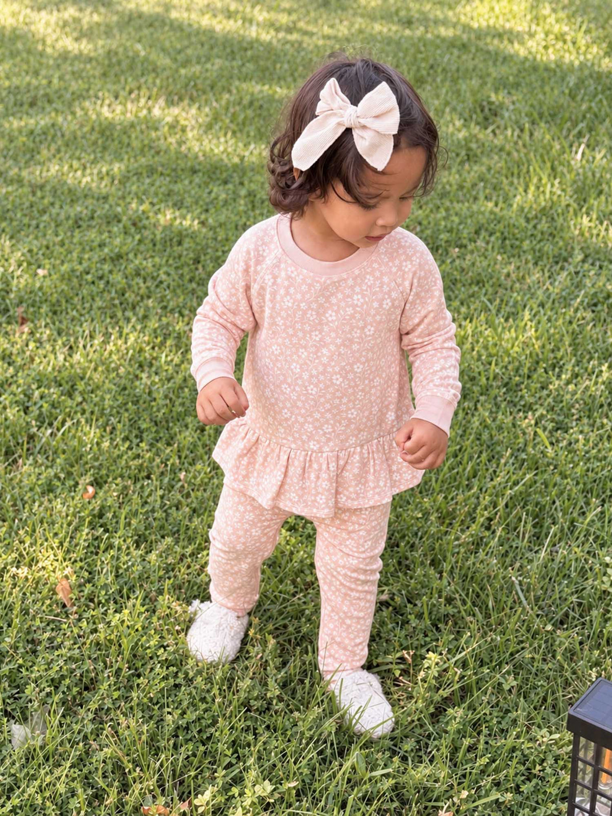 Light pink fleece two-piece sweatsuit with ruffled top and floral pattern leggings