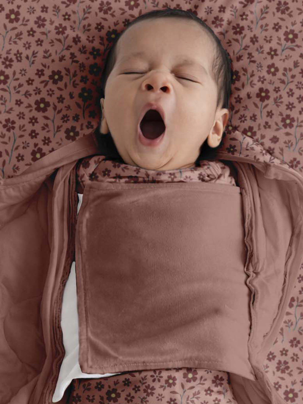 Pink swaddle sleep sack with floral upper panel and rounded neck opening