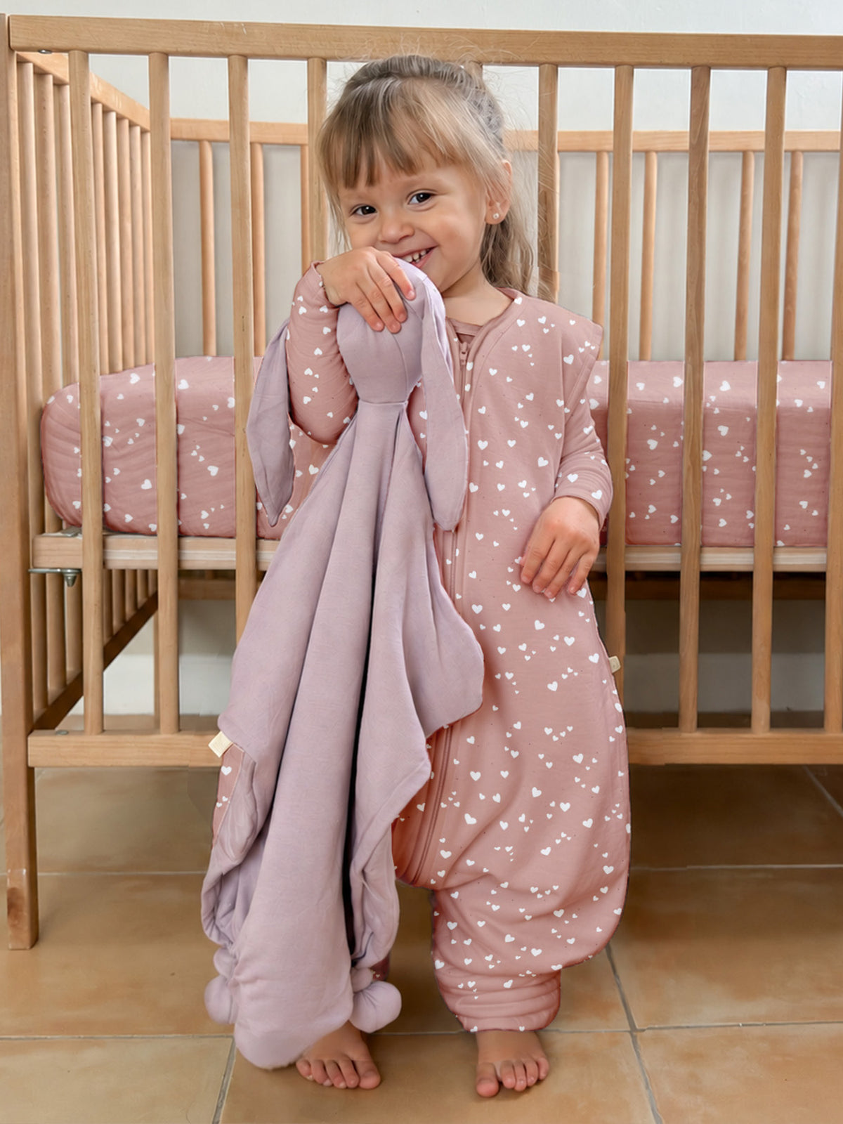 Pink heart-print footed sleep sack with long sleeves and enclosed feet, front view, 2.5 TOG