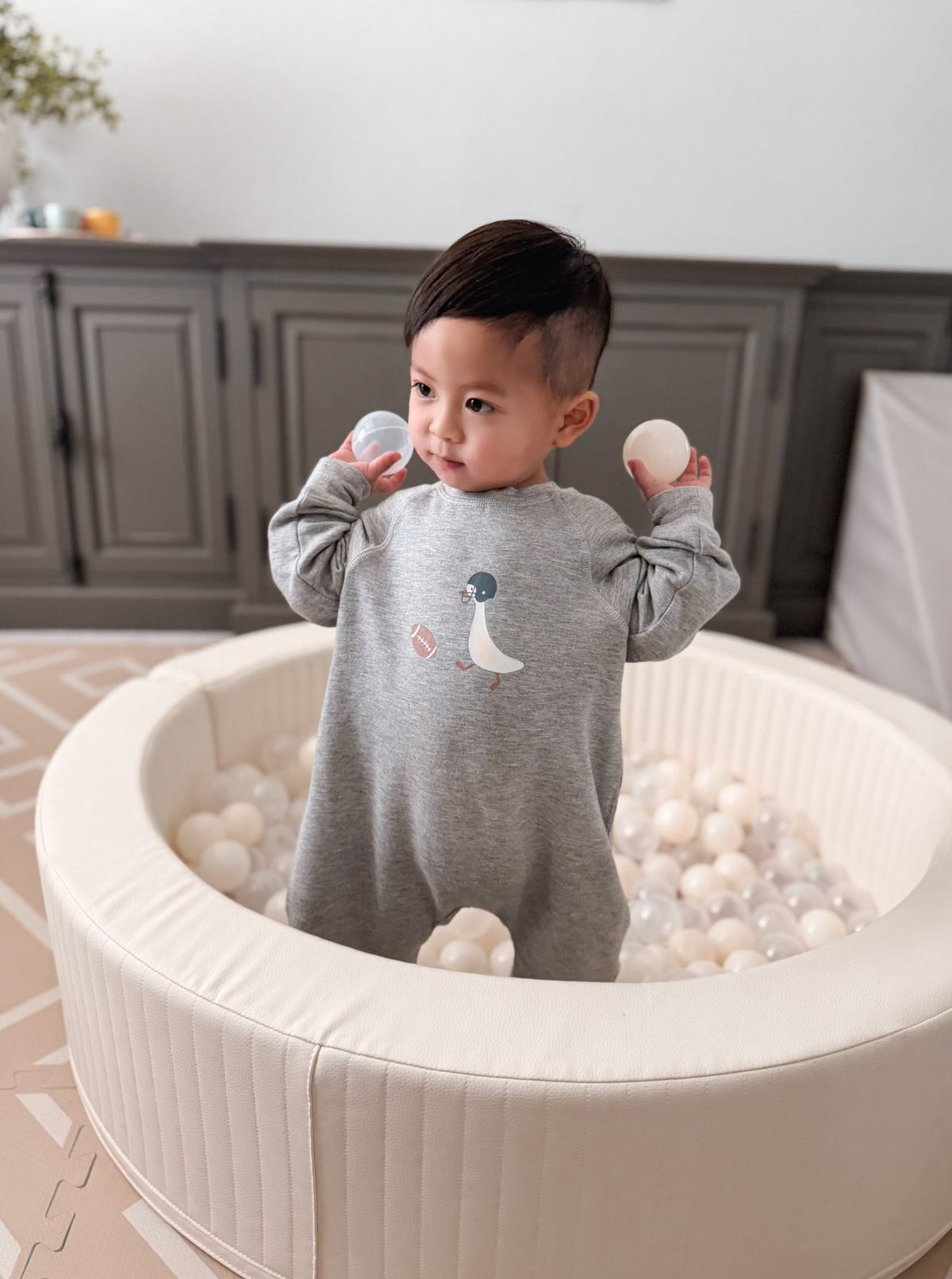 Gray fleece jumpsuit with goose applique, long sleeves, and cuffed legs.