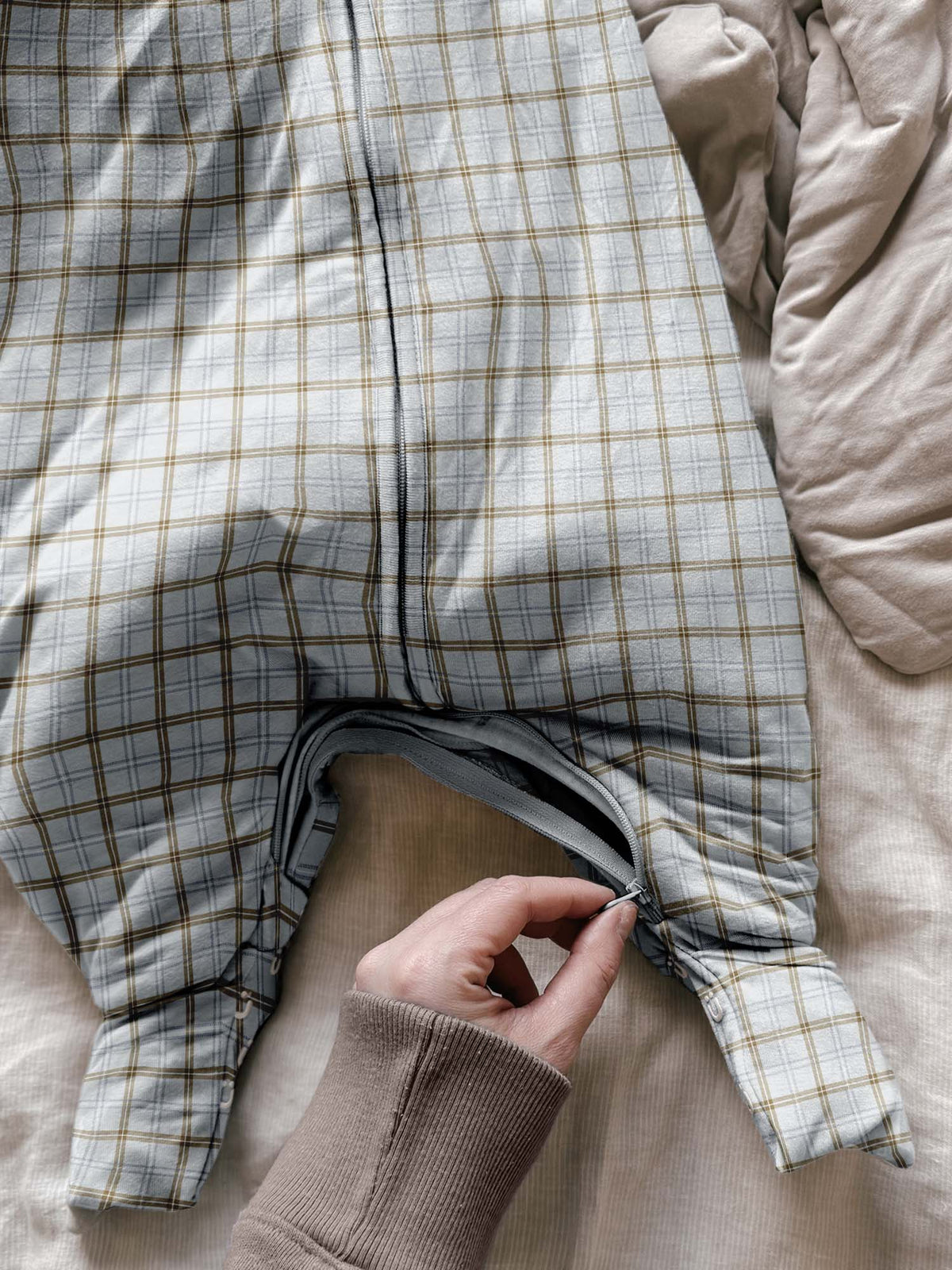 Close-up of plaid long-sleeve footie sleep sack: front zipper and open foot