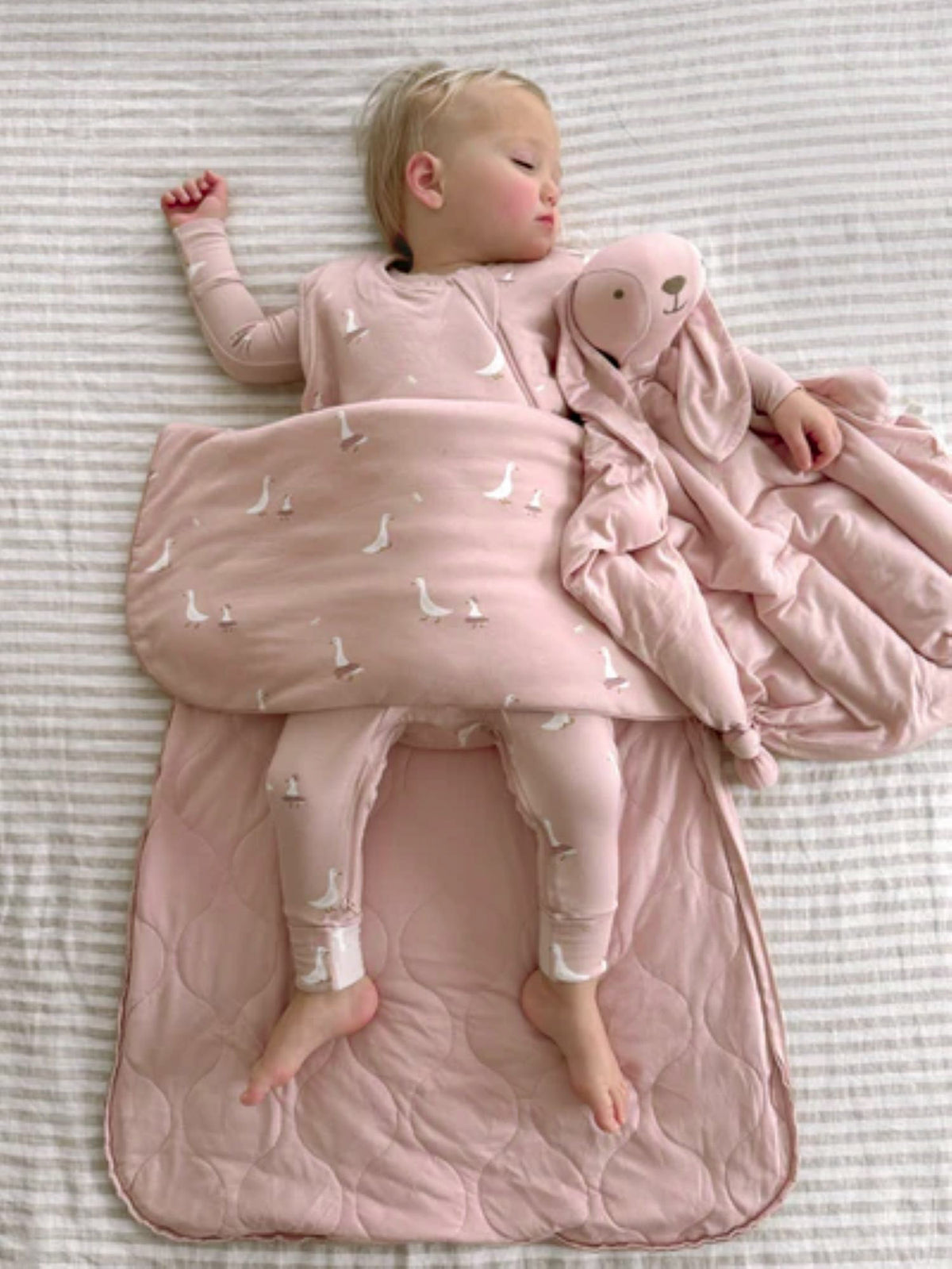 Pink 1.0 TOG sleep sack with white goose pattern and bunny-shaped hood