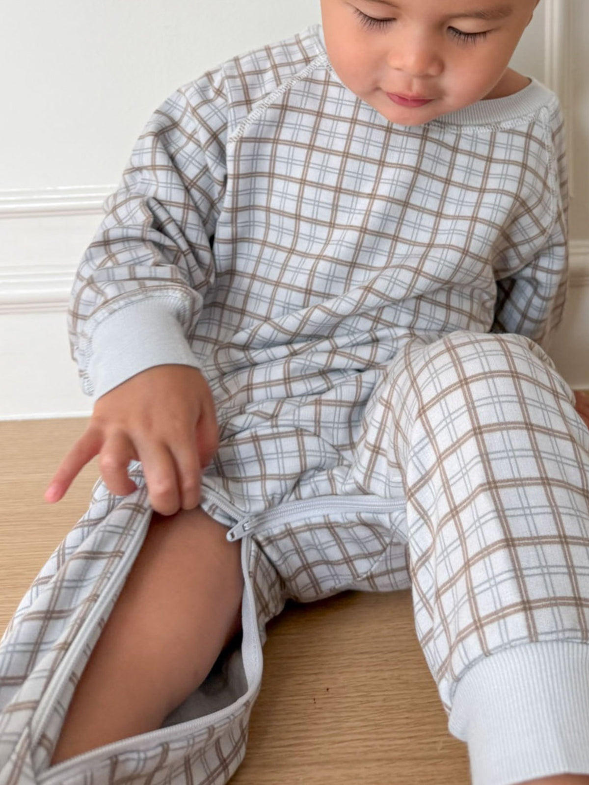 Plaid fleece baby jumpsuit, crew neck and ribbed cuffs, light blue/tan grid