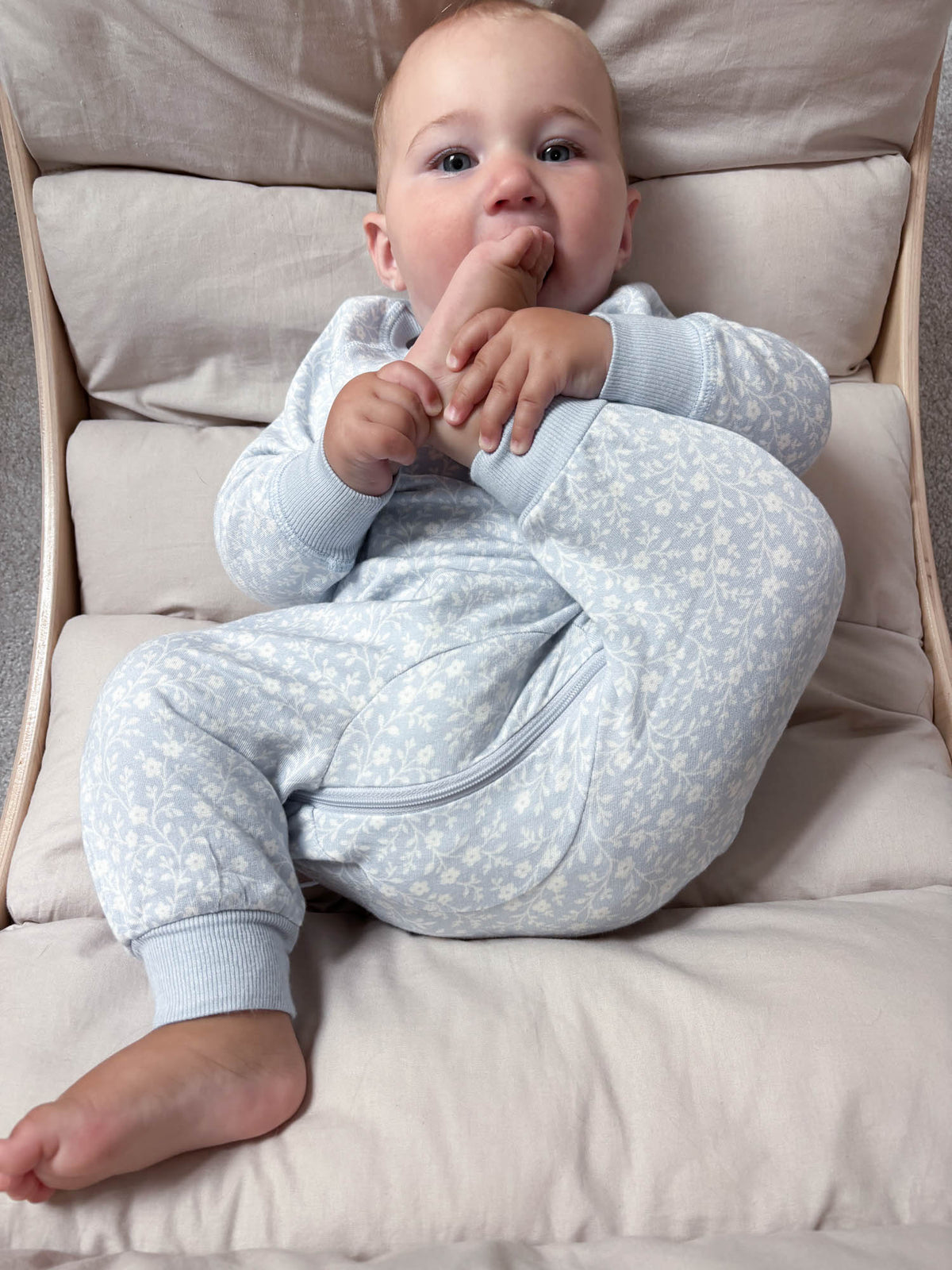 Light blue fleece footed jumpsuit with white floral print and front zipper